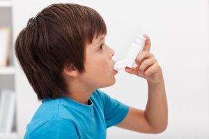 Boy using inhaler - respiratory system illness